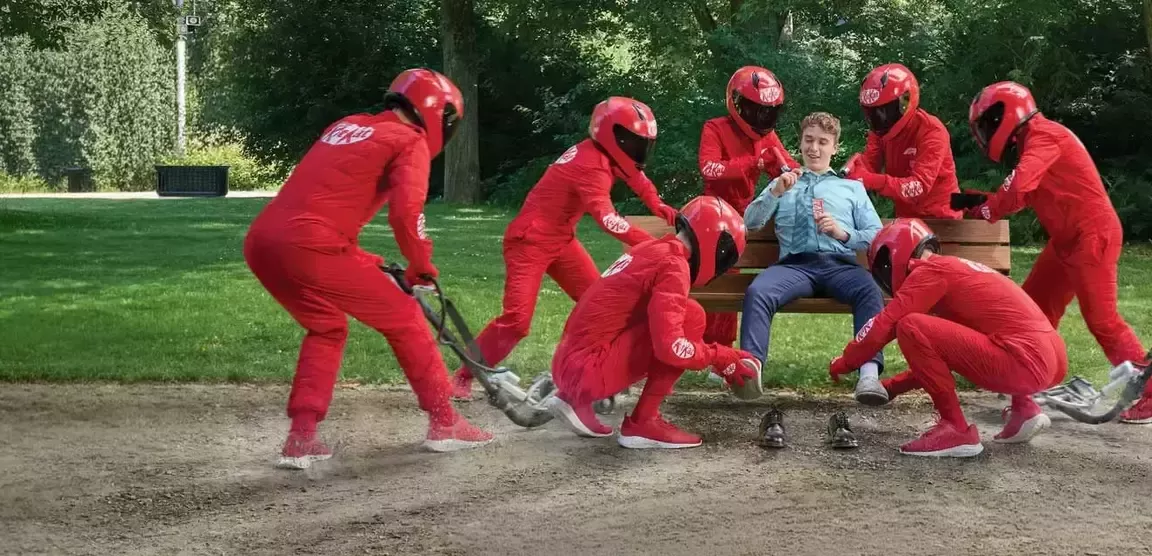 KitKat F1 žmonės raudonais kostiumais