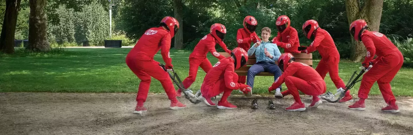 KitKat F1 žmonės raudonais kostiumais